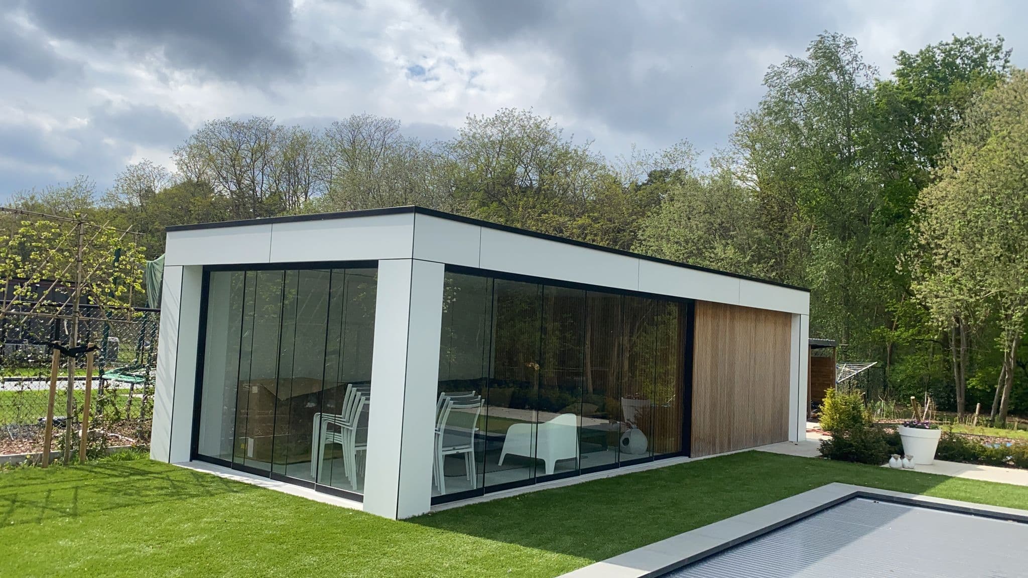 Glazen schuifwand interieur bij een houten tuinkamer overkapping