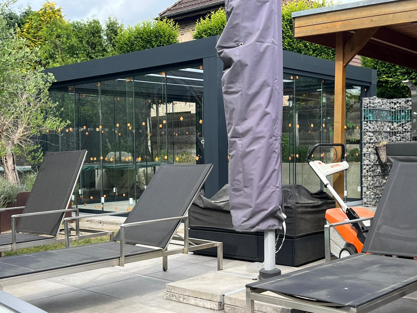 Gerealiseerd project: aluminium veranda met glazen schuifwanden en terrasinrichting